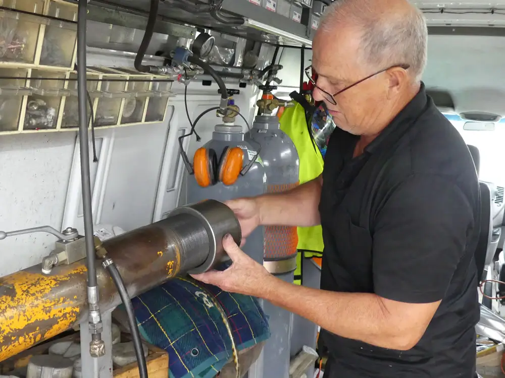 A technician servicing a gas strut